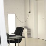 Creative Organization - Interior of spacious loft studio with meeting table and chairs surrounded by hanging white curtains