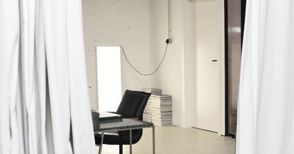 Creative Organization - Interior of spacious loft studio with meeting table and chairs surrounded by hanging white curtains