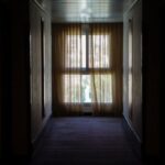 Choosing Curtains - hallway leading to window covered by brown window curtain
