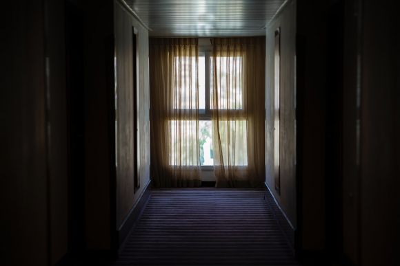 Choosing Curtains - hallway leading to window covered by brown window curtain