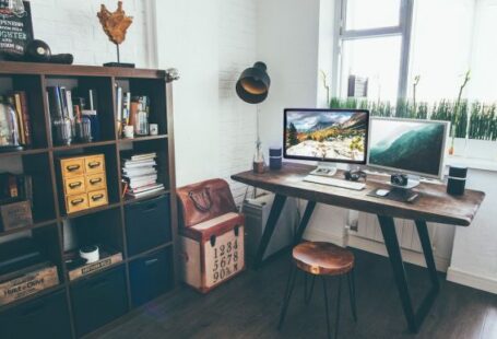 Home Workspace - two flat screen monitor turned on near organizer rack inside the room