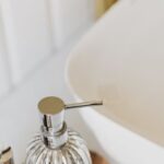 Trendy Essentials - Set of stylish cosmetic products placed near sink in bathroom