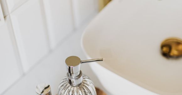 Trendy Essentials - Set of stylish cosmetic products placed near sink in bathroom