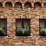 Window Treatments - a brick building with three windows with plants in them