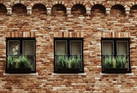 Window Treatments - a brick building with three windows with plants in them