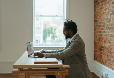 Home Office - a person sitting at a desk with a laptop and papers