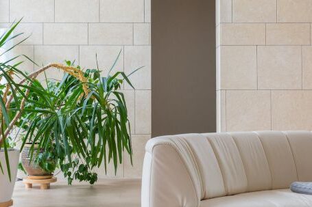 Luxury Properties - Contemporary interior of living room with soft sofa and timber round shaped table near verdant plants