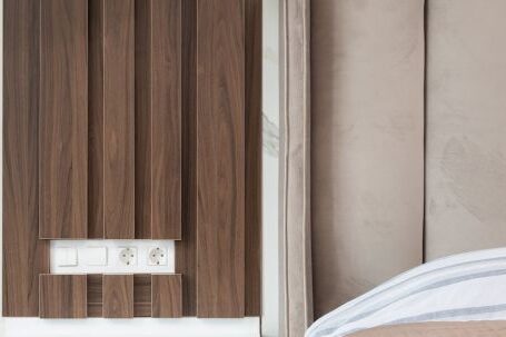 Luxury Properties - Interior of modern hotel room with bed next to bedside table under lamp hanging from ceiling