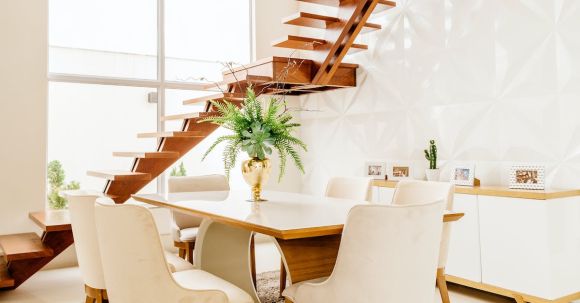 Interior Design - Minimalistic design of spacious room with second level space and wooden staircase against large windows in modern house in daytime