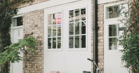 Property - Black Bicycle Parked Beside White Wooden Chair