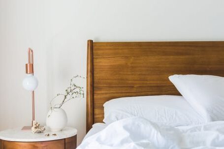 Interior Design - White Bedspread Beside Nightstand With White and Copper Table Lamp