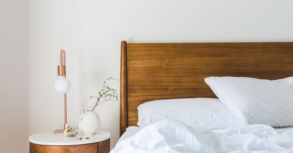 Interior Design - White Bedspread Beside Nightstand With White and Copper Table Lamp