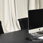 Luxury Properties - Black and white of contemporary computer placed on table in simple contemporary workplace of office