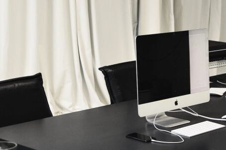 Luxury Properties - Black and white of contemporary computer placed on table in simple contemporary workplace of office