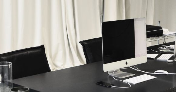 Luxury Properties - Black and white of contemporary computer placed on table in simple contemporary workplace of office