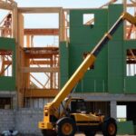 Real Estate - Yellow and Black Heavy Equipment Near Unfinished Building