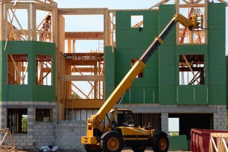 Real Estate - Yellow and Black Heavy Equipment Near Unfinished Building