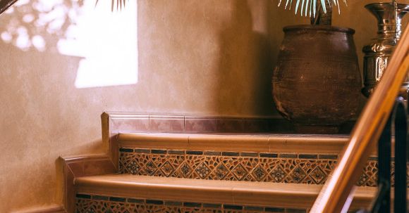 Luxury Properties - Interior with stone staircase with ornament and reflection of palm on wall