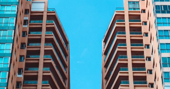 Property - Low Angle View of Two High Rise Buildings Under Blue Sky