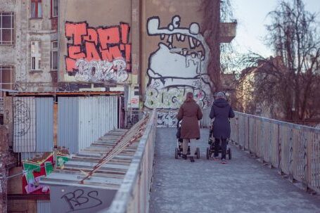 Neighborhood - Two People Walking on Bridge