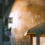 Neighborhood - Unrecognizable people walking along arched passage at sunrise