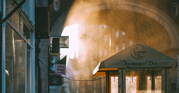 Neighborhood - Unrecognizable people walking along arched passage at sunrise