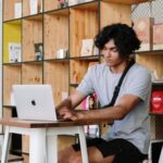 Shelvs - Man in White Crew Neck T-shirt Sitting on White Wooden Chair