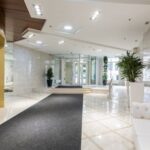 Luxury Properties - Interior of contemporary spacious lobby without people with white leather sofa and long black carpet