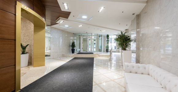 Luxury Properties - Interior of contemporary spacious lobby without people with white leather sofa and long black carpet