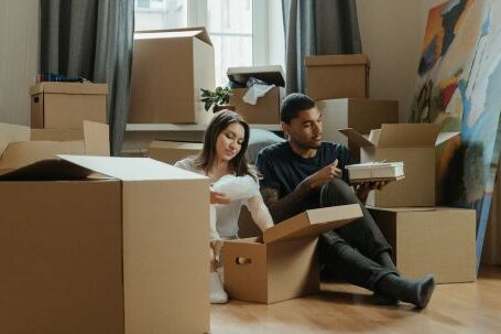 New Home - 2 Boys and Girl Sitting on Brown Cardboard Box