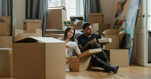 New Home - 2 Boys and Girl Sitting on Brown Cardboard Box