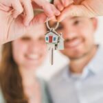 New Home - Happy Couple Holding and Showing a House Key