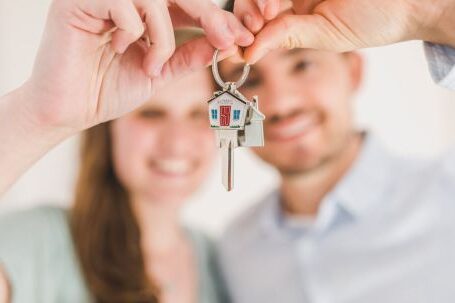 New Home - Happy Couple Holding and Showing a House Key