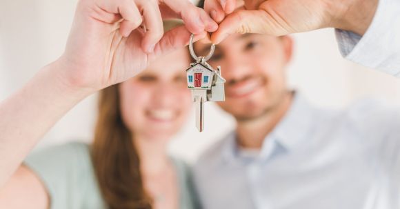 New Home - Happy Couple Holding and Showing a House Key
