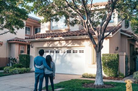 New Home - Couple Standing In Front of their House