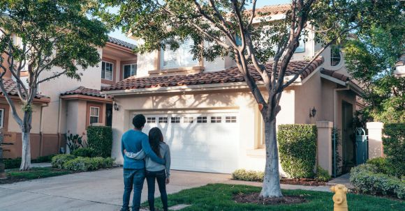 New Home - Couple Standing In Front of their House