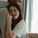 New Home - Man in Gray Shirt Hugging Woman in White Dress