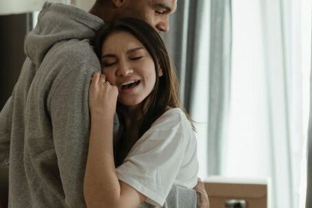 New Home - Man in Gray Shirt Hugging Woman in White Dress