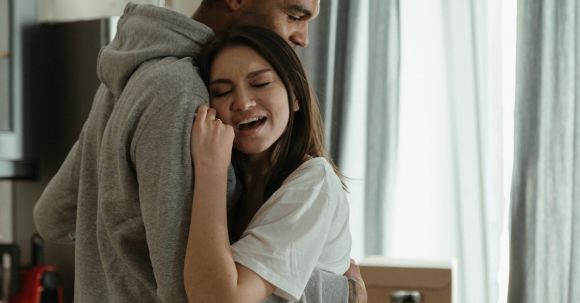 New Home - Man in Gray Shirt Hugging Woman in White Dress