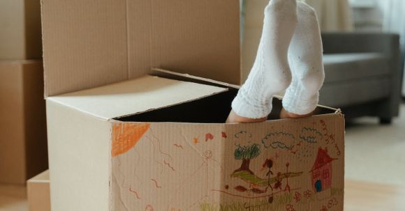 New Home - Brown Cardboard Box on Brown Wooden Table