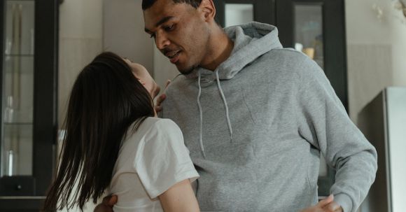 New Home - Man in Gray Hoodie Kissing Woman in White Dress