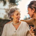Garden Care - Joyful adult daughter greeting happy surprised senior mother in garden