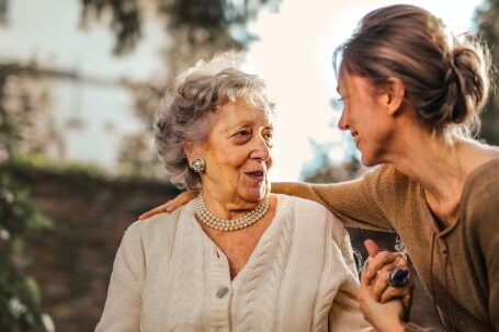 Garden Care - Joyful adult daughter greeting happy surprised senior mother in garden