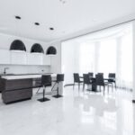 Luxury Properties - Interior of modern spacious kitchen with minimalist furniture and shiny marble styled floor decorated with creative white pots of fresh green plants