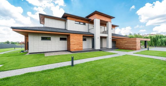 Luxury Properties - Exterior of residential house with green trees and lawn growing in countryside in summertime