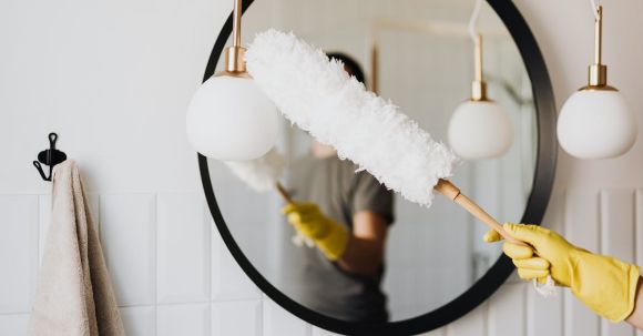 Cleaning - Crop woman dusting lamp during housework