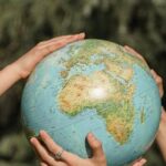 Eco Travel - People Holding a Globe