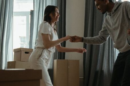 New Home - Man in White Dress Shirt and Black Pants Standing Beside Woman in White Long Sleeve Shirt