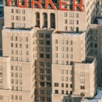 Neighborhood - Drone view of modern multistory hotel located on street with residential houses in megapolis with bright sunlight in New York