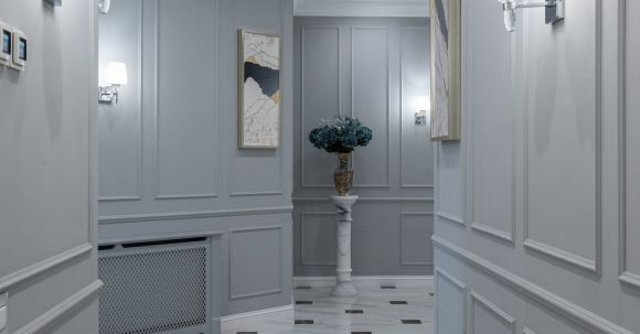 Luxury Properties - Elegant shining lamps and paintings hanging on gray walls in hallway of classic styled house with marble floor
